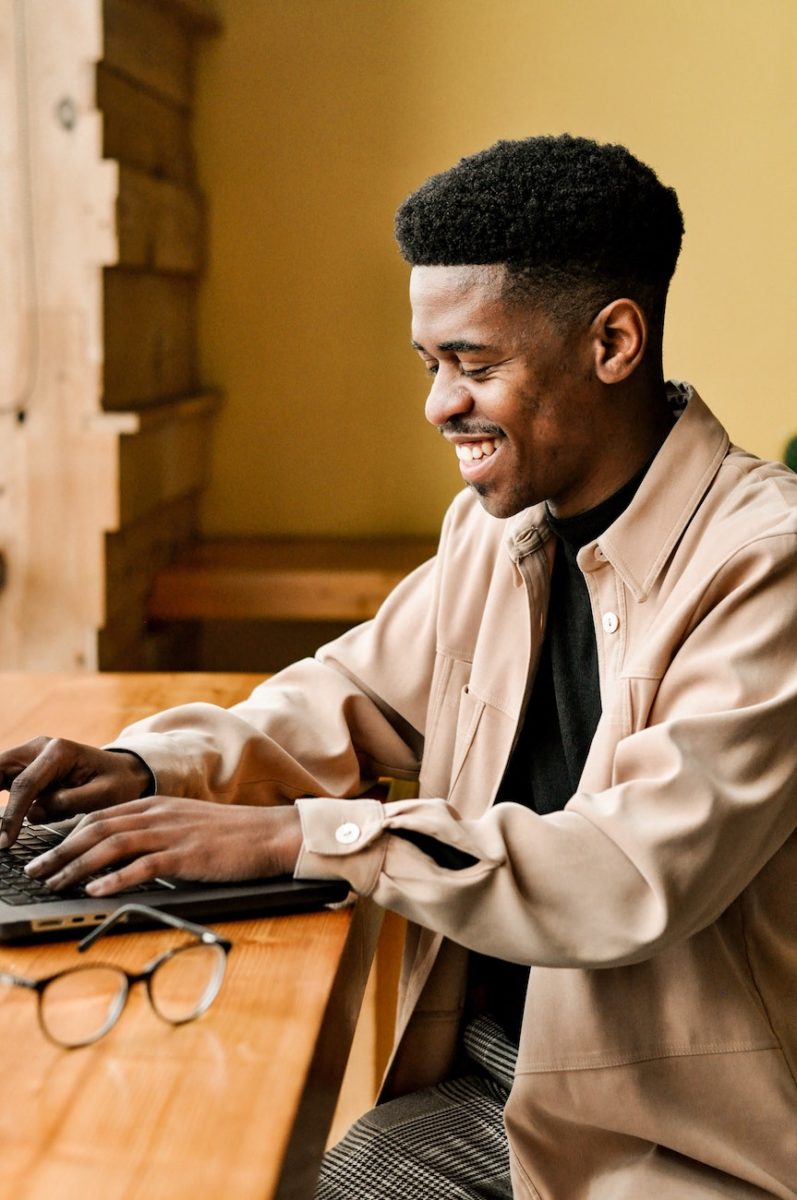 man smiling, on his laptop. restorative package.