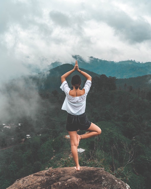 woman in tree pose on a mountain top