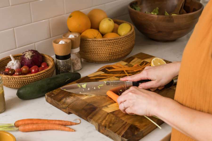 Asheville nutritionist chopping veggies on cutting board