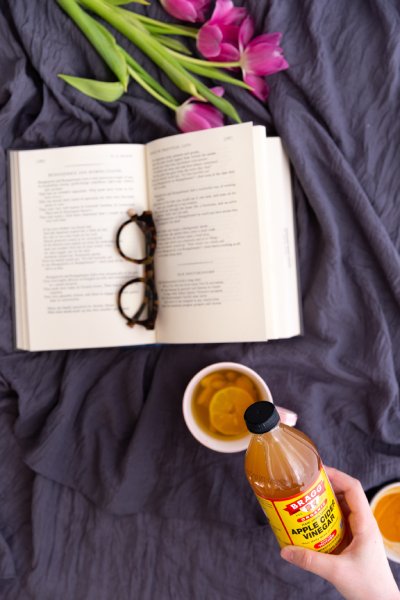 sunglasses on top of an open book; Bragg's apple cider vinegar